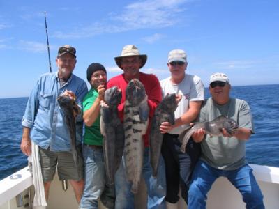 This group of anglers from the US Coast Guard yard in Baltimore, MD display wolf fish they caught aboard RELENTLESS during a cod and haddock charter